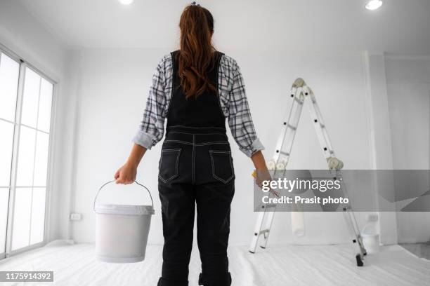 low angle view of one painter woman at work with a roller, bucket and ladder in new house. woman life and lifestyle for new house activity concept - whitewashed stock pictures, royalty-free photos & images