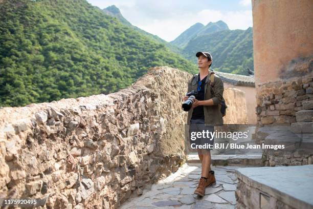 chinese photographer walking in village - asian photographer stock pictures, royalty-free photos & images