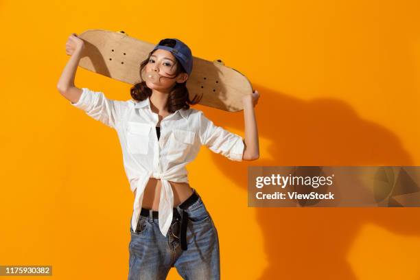 young girl with a skateboard - east asian ethnicity fotografías e imágenes de stock
