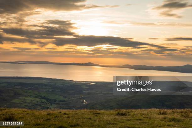 sunset over tremadog bay and view to the lleyn peninsula from y llethr;image taken from the cambrian way between barmouth and the summit of y lethr, which is the highest point in the rhinog mountains. august - tremadog bay stock pictures, royalty-free photos & images