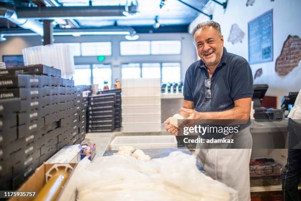 senior italiaanse man werkt pizza deeg - pizzeria stockfoto's en -beelden