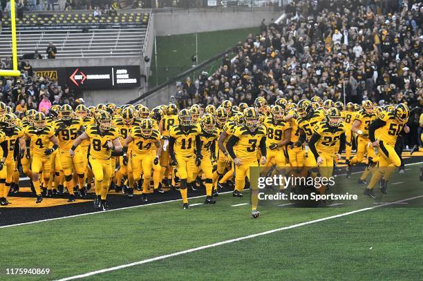 The Iowa Hawkeyes take the field sporting special all yellow uniforms before a Big Ten Conference football game between the Penn State Nittany Lions...