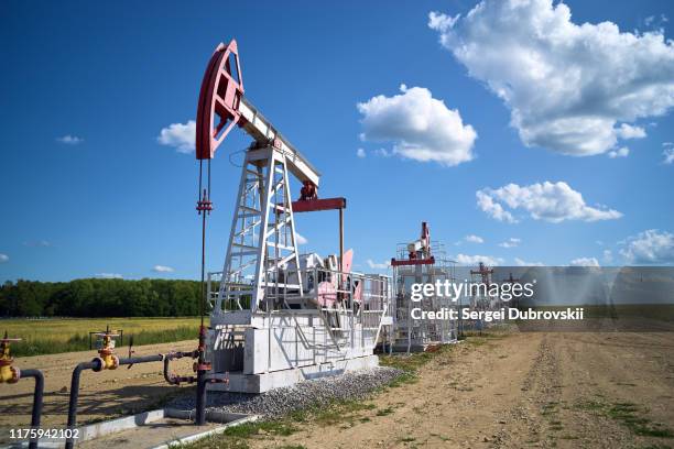 oliepomp, veld, blauwe bewolkte hemel - russia stockfoto's en -beelden