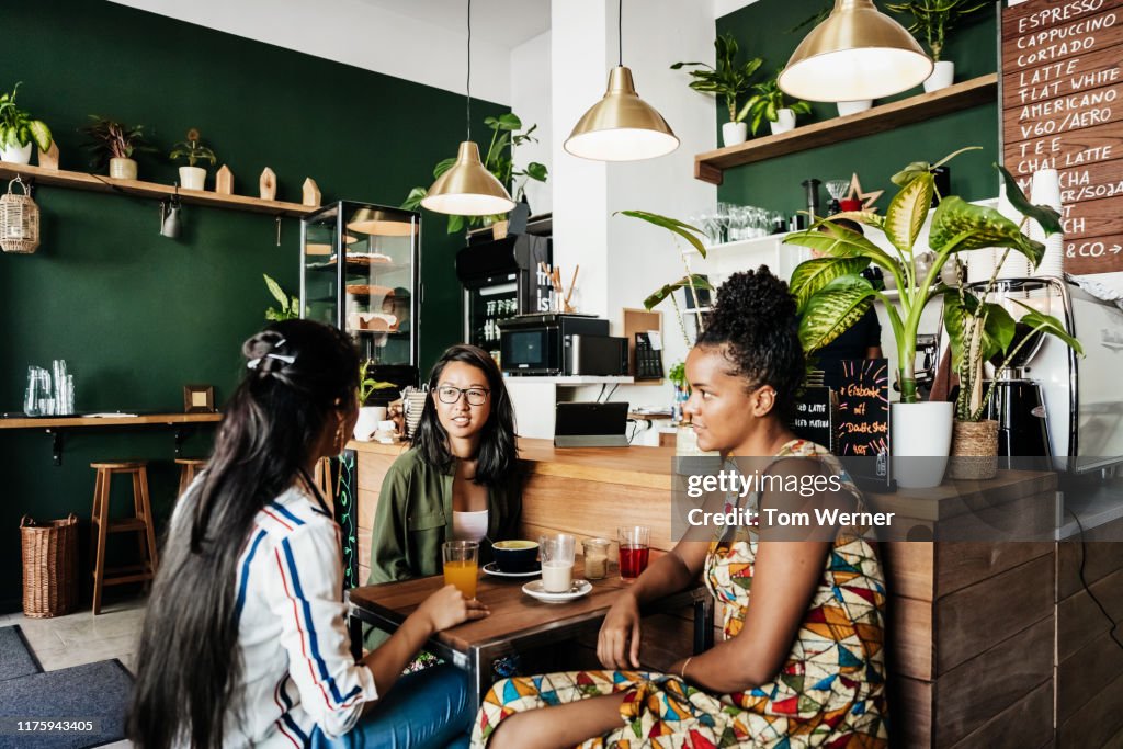 Group Of Girls Sitting In Coffee Shop Chatting