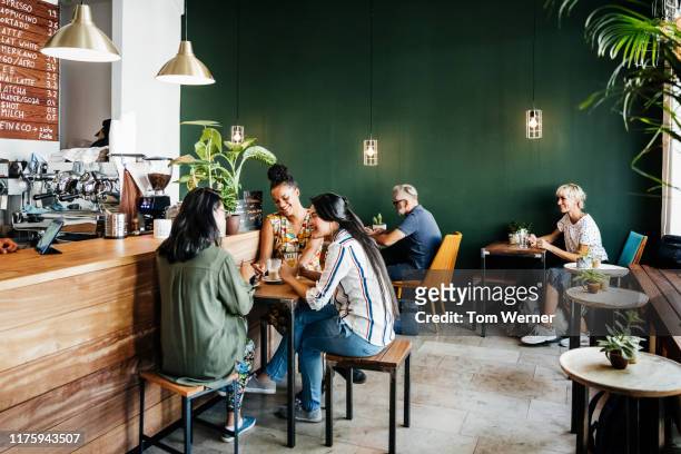 busy coffee shop with customers sitting down - コーヒーショップ ストックフォトと画像