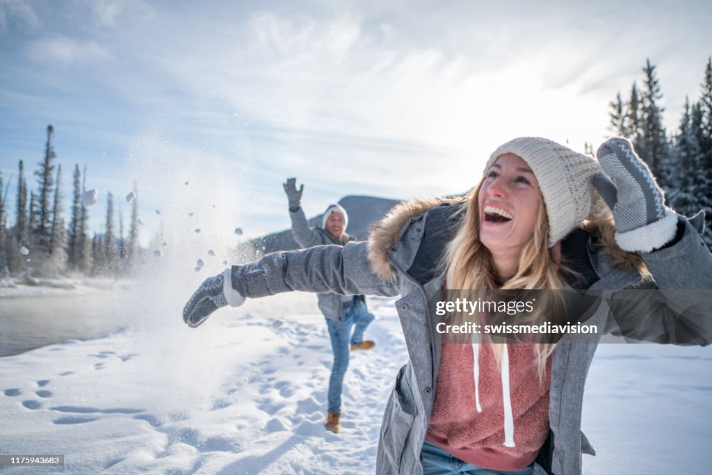 Verspieltes Paar Schneeballkampf im Winter