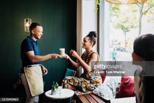 barista serving customer coffee - women serving coffee stock-fotos und bilder