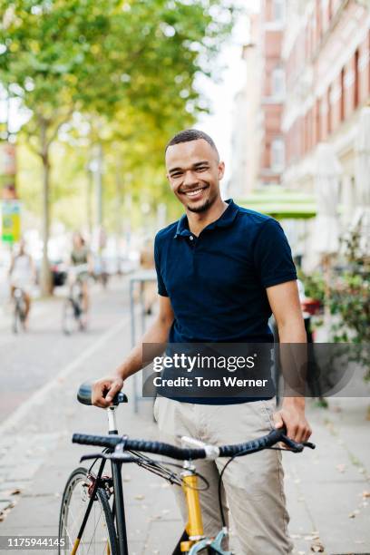 portrait of young man and his bicycle - cycling streets photos et images de collection