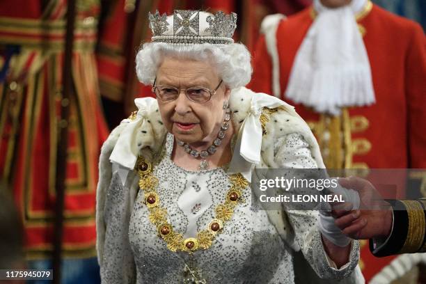 Britain's Queen Elizabeth II proceeds through the Royal Gallery to deliver the Queen's speech at the State Opening of Parliament in the Houses of...