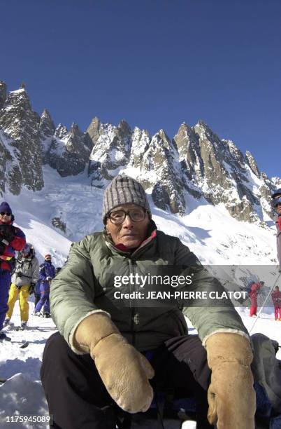 Keizo Miura , un Japonais de 99 ans, se repose devant les Aiguilles des grands Charmoz, le 19 février 2003, lors de sa descente à ski de l'arrête de...