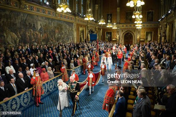 Britain's Queen Elizabeth II is accompanied by her son Britain's Prince Charles, Prince of Wales as they proccess through the Royal Gallery during...