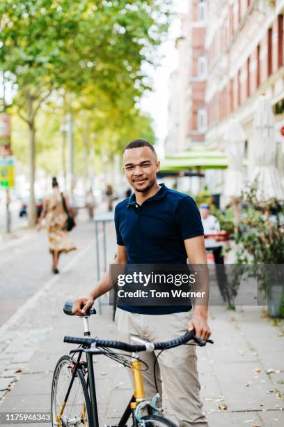 portrait of young man standing with bicylce - navy blue polo shirt stock pictures, royalty-free photos & images