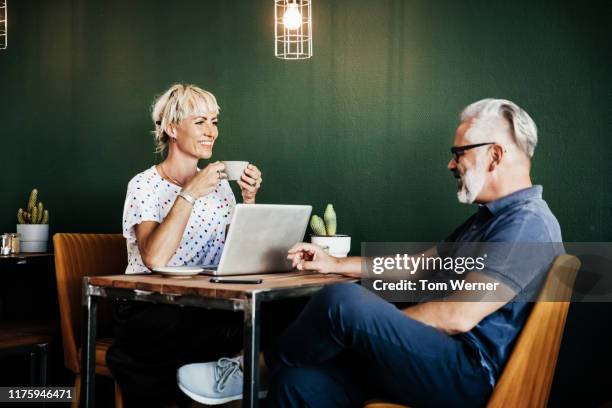 two friends sitting in cafe together chatting over coffee - coffee meeting with friends stock pictures, royalty-free photos & images