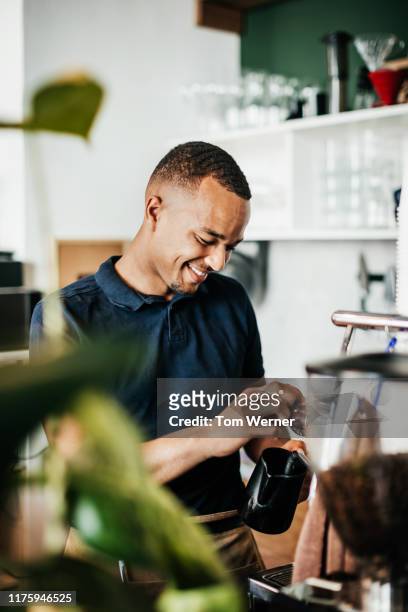 barista heating up some milk while making coffee - barista stock pictures, royalty-free photos & images