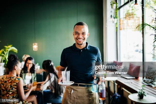 portrait of cafe waiter clearing tables - servitör bildbanksfoton och bilder