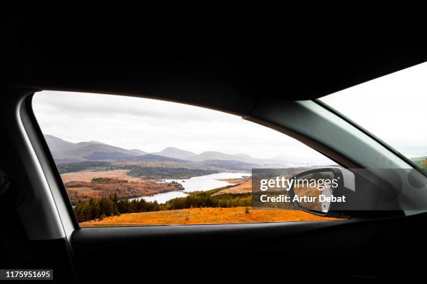 the scotland highlands view in autumn from the car. - classic car point of view stockfoto's en -beelden