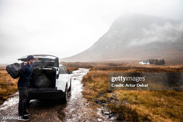 unpacking from car during vacations in scotland with rainy day. - car rental stock pictures, royalty-free photos & images