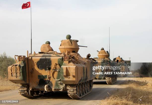 Turkish soldiers are trasported in armoured personnel carriers through the town of Tukhar, north of Syria's northern city of Manbij, on October 14 as...