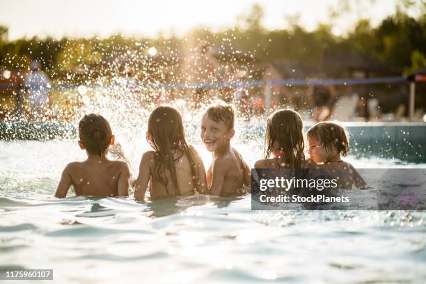 kinder genießen das planschen im pool - girls and boys playing in waterpark stock-fotos und bilder