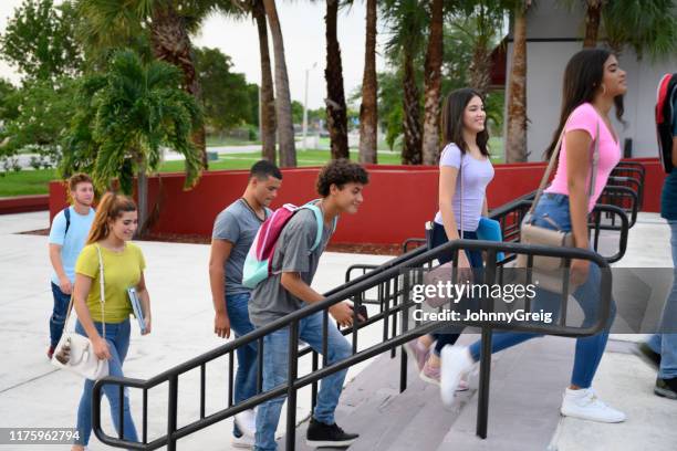 hispanic teenage students walking into school in the morning - high school building exterior stock pictures, royalty-free photos & images