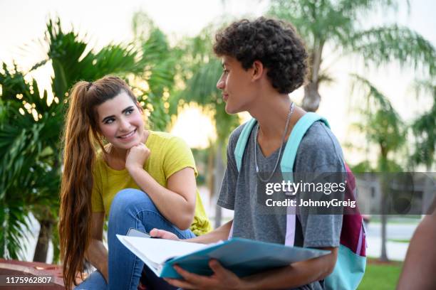 teenage hispanic classmates interacting before school begins - girl flirting stock pictures, royalty-free photos & images