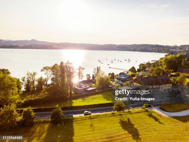 view of the setting sun over lake attersee - attersee stock-fotos und bilder
