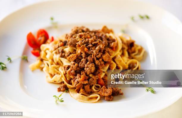 plate of tagliatelle pasta with bolognese sauce - tagliatelle foto e immagini stock