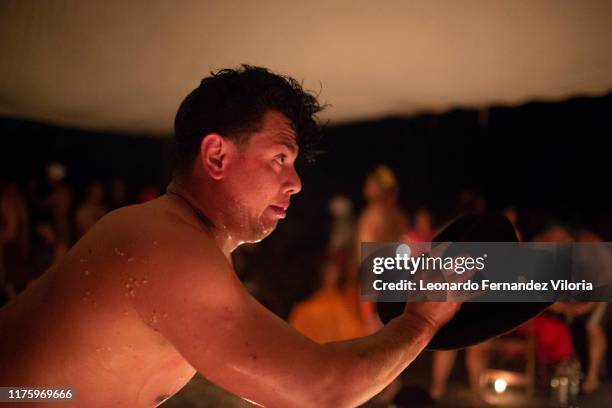 Man who is trance by a spirit of an old man called "Chamarrers" greets Queen Maria Lionza during a spiritual ritual in a portal at mountain Sorte on...