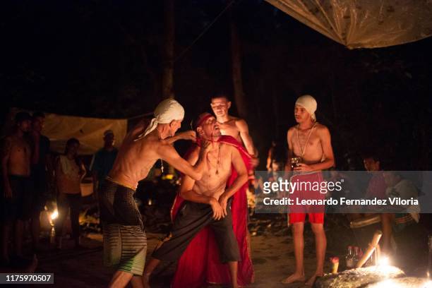 Man who is trance by a spirit of a viking warrior is dressed in a red cape in during a spiritual ritual in a portal deep in the mountain of sorte on...