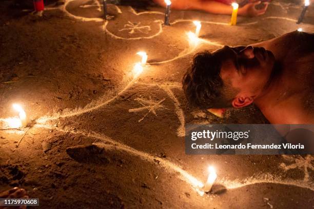 Man participates in a healing ritual called "Velación" at night during a spiritual ritual in a portal in the mountain of Maria Lionza at Sorte on...