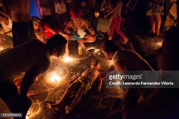 Little boy participates in a healing ritual called "Velación" at night during a spiritual ritual in a portal in the mountain of Maria Lionza at Sorte...