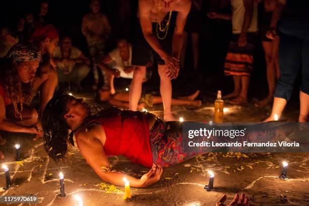 Women participates in a healing ritual called "Velación" at night during a spiritual ritual in a portal in the mountain of Maria Lionza at Sorte on...