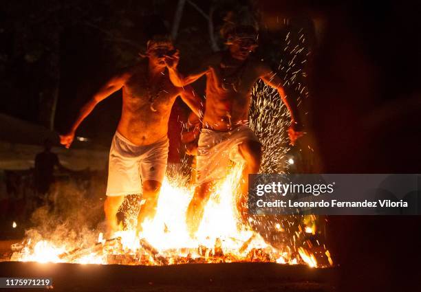 Two men who are in a trance for the spirits of Indian warriors called "Caciques" they step on the burning flames with bare feet in honor of these...