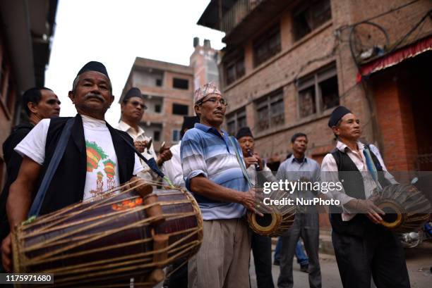 Devotees playing traditional drums as Locals carry and rotates top part of a chariot of Lord Narayan across the streets of Hadigaun during Lord...