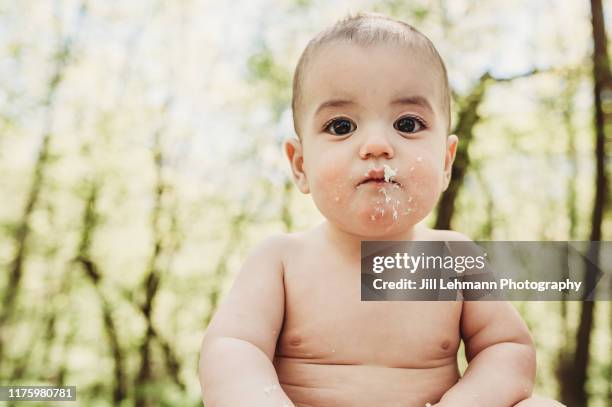 1 year old fraternal twin brother smashes cake wearing only diapers on their first birthdays - cake smashing stock pictures, royalty-free photos & images