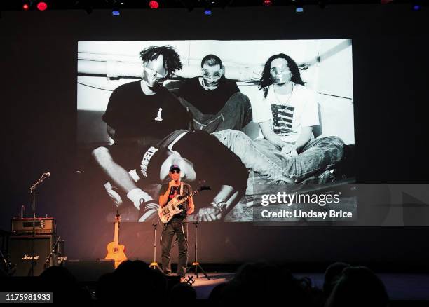 Tom Morello performs SPEAKING TRUTH TO POWER THROUGH STORIES AND SONG before projection of 1992 photograph of Rage Against the Machine by this...