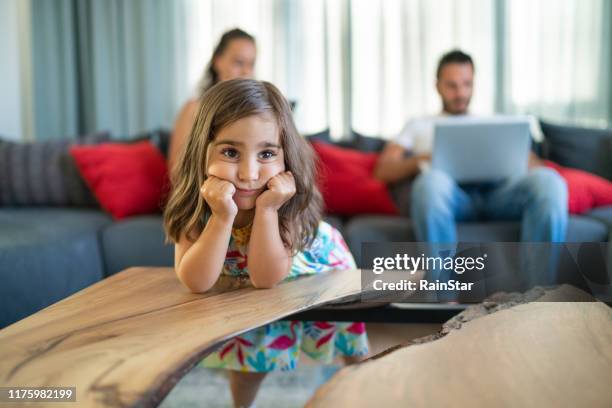 verticale de garçon de tristesse avec sa mère et père avec la fille ennuyée utilisant l'ordinateur portatif sur le sofa. - exclusion photos et images de collection