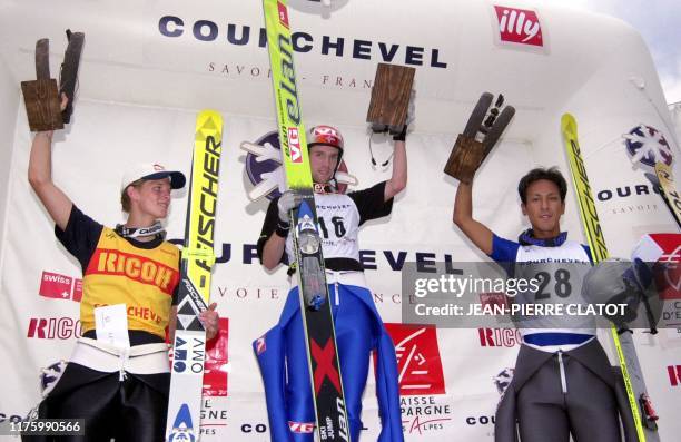 L'Autrichien Thomas Morgensen , le Norvégien Sigurd Pettersen , et le Japonais Noriaki Kasai , brandissent leur trophée, le 14 août 2003 sur le...