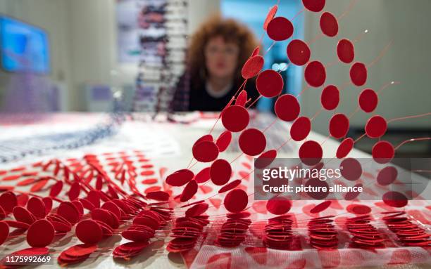 October 2019, Saxony-Anhalt, Halle : A woman observes the work "Zwischen_Räumen" by Magdalena Sophie Orland during a preview of an exhibition at Burg...