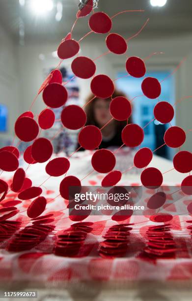 October 2019, Saxony-Anhalt, Halle : A woman observes the work "Zwischen_Räumen" by Magdalena Sophie Orland during a preview of an exhibition at Burg...