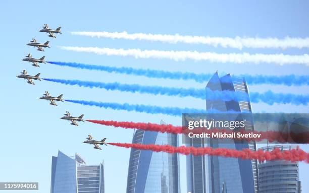 Jet fighters fly over the Gasr Al Watan Palace with smoke in the colours of the Russian flag for the arrival of Russian President Putin in Abu Dhabi...