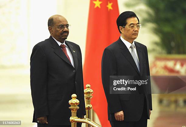 President of Sudan Omar al-Bashir and Chinese President Hu Jintao listen to the national anthems during a welcoming ceremony at the Great Hall of the...