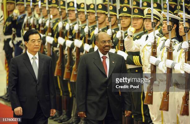 Chinese President Hu Jintao and President of Sudan Omar al-Bashir review the Chinese military honour guard during a welcoming ceremony at the Great...