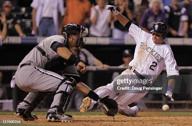 Troy Tulowitzki of the Colorado Rockies slides home with the winning run past catcher A.J. Pierzynski of the Chicago White Sox on a single by Ty...