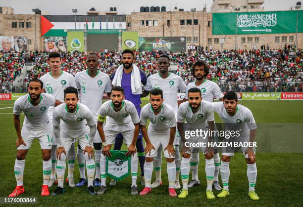 Saudi Arabia's starting eleven pose for a group picture as they line-up before the World Cup 2022 Asian qualifying match between Palestine and Saudi...