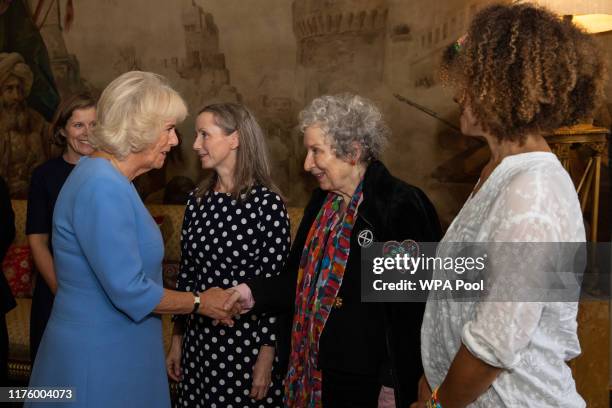 Camilla, Duchess of Cornwall shakes hands with 2019 Booker prize winner Margaret Atwood as fellow 2019 Booker prize winner Bernardine Evaristo and...