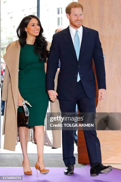 Britain's Prince Harry , Duke of Sussex, and his wife Meghan, Duchess of Sussex react as they arrive to attend the annual WellChild Awards in London...