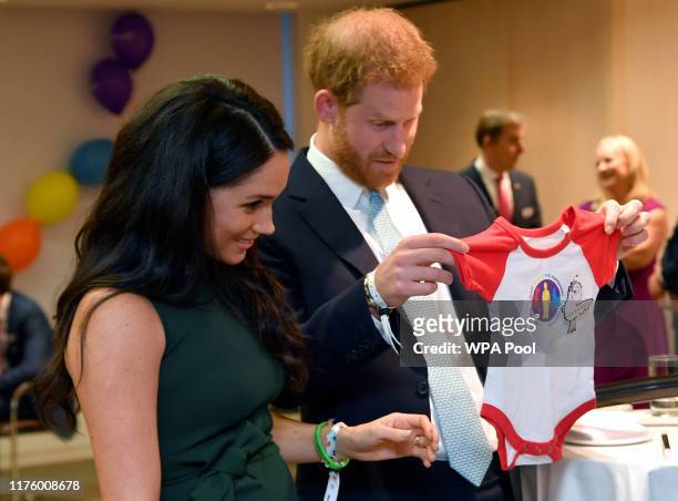 Prince Harry, Duke of Sussex and Meghan, Duchess of Sussex view a gift for their son Archie as they attend the WellChild awards at Royal Lancaster...