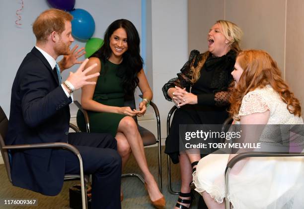 Britain's Prince Harry, Duke of Sussex, and Britain's Meghan, Duchess of Sussex talk with Milly Sutherland and her mother Angela as they attend the...