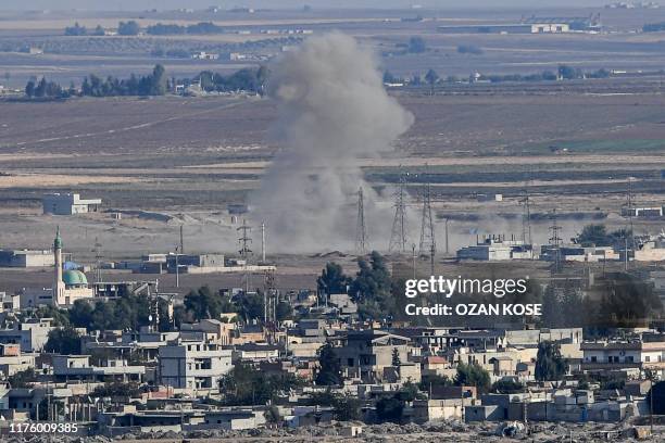 This picture taken on October 15, 2019 from the Turkish side of the border at Ceylanpinar district in Sanliurfa shows smoke rising from the Syrian...